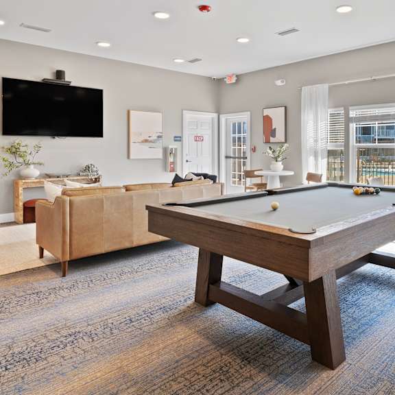 A room with a pool table and a tv.