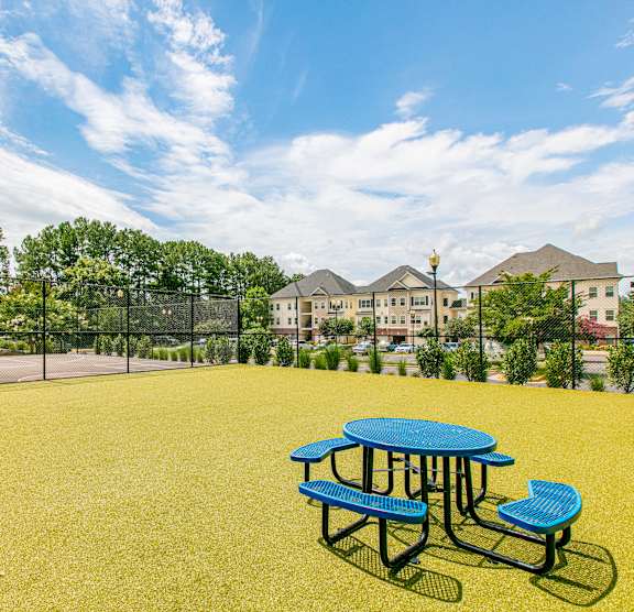 A large room with a blue couch and a chandelier. at Barrington Park Apartments, Manassas