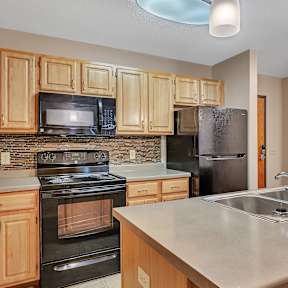 a kitchen with black appliances and wooden cabinets
