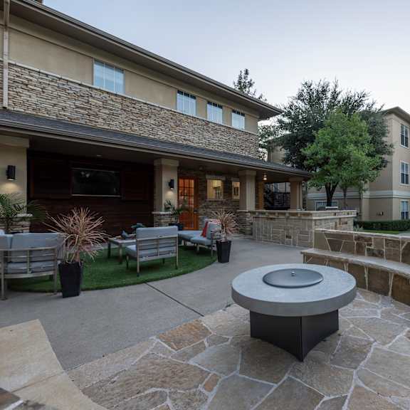 Stone patio with a firepit at Woodbridge Villas Apartments, Sachse, Texas