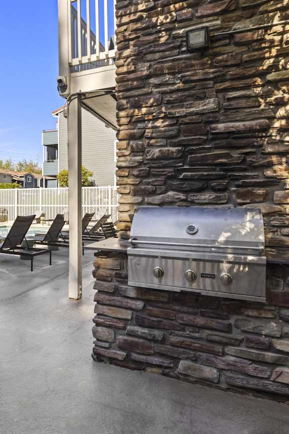 a swimming pool with orange chairs in front of a house at 2000 Lake Washington Apartments, Renton, WA, 98056