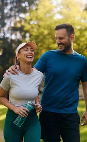 A man and a woman are walking in a park. at Bonnie Brae Apartments, California