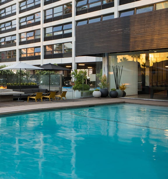 a large building with a swimming pool in front of it at The Flat in Los Angeles, CA 90017