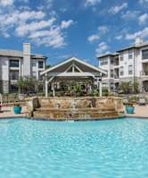 A swimming pool in front of a building with a gazebo.