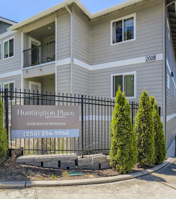 A building with a sign that says Huntington Place in front of it.