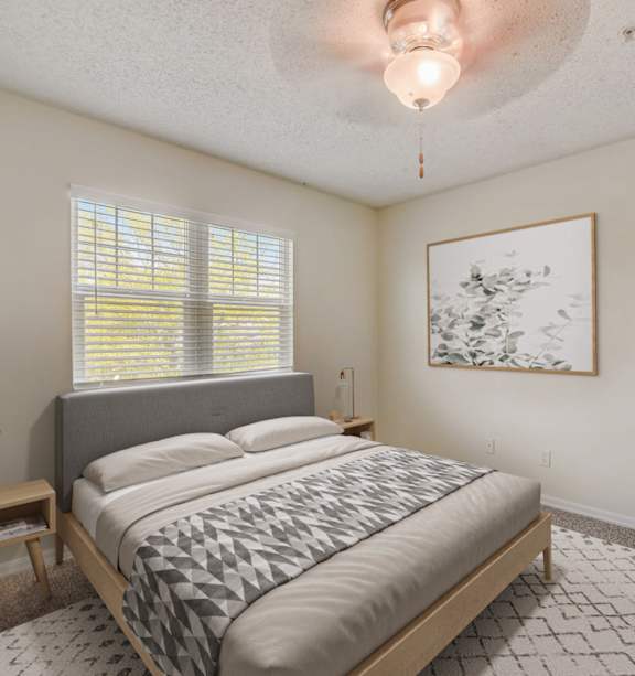 A bedroom with a bed, nightstand, and window.