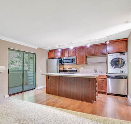 A modern kitchen with a fireplace and wooden cabinets.