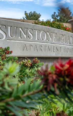 a sign for sunstone reef apartments with flowers in front of it at Sunstone Place, Riverside, CA, 92505
