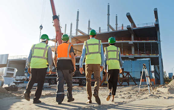 a group of construction workers walking in front of a building
