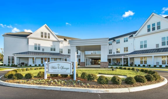 A large white building with a sign that reads  at White Springs Senior Living, Warrenton, Virginia