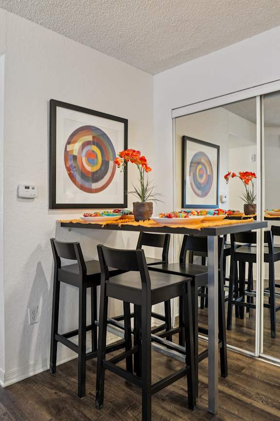 A kitchen with a black refrigerator, black oven, and wooden cabinets.