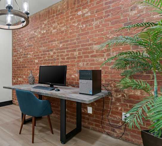 A room with a desk, chair, and computer setup.