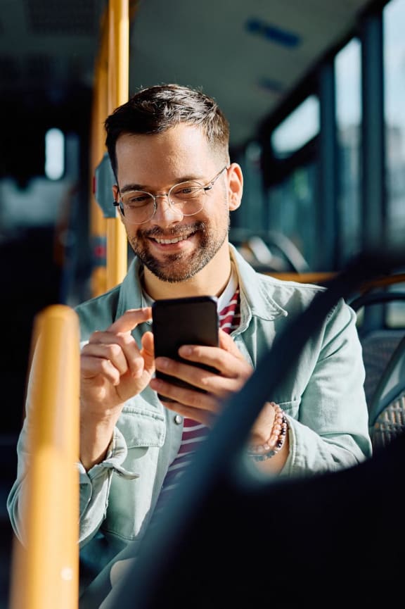 a man on a bus looking at his cell phone  at SoRoc On Maine, Rochester, MN