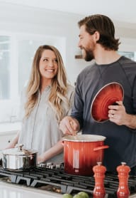 a man and a woman standing in a kitchen stirring a pot on a stove at Cambridge on Seventh, Puyallup, WA, 98372