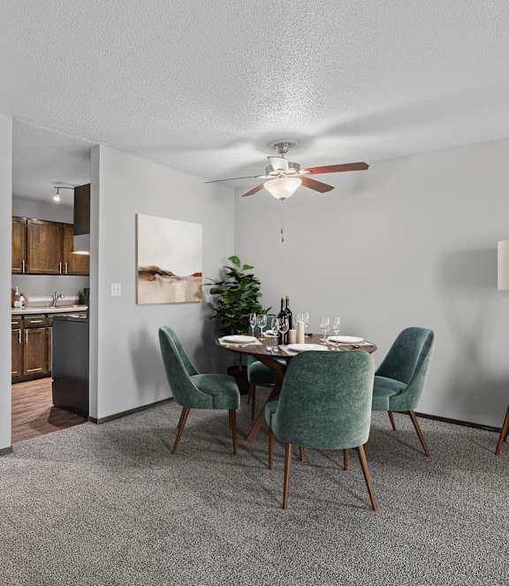 A dining room with a table set for two and a potted plant.
