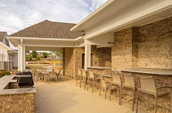 A patio area with a bar and chairs.