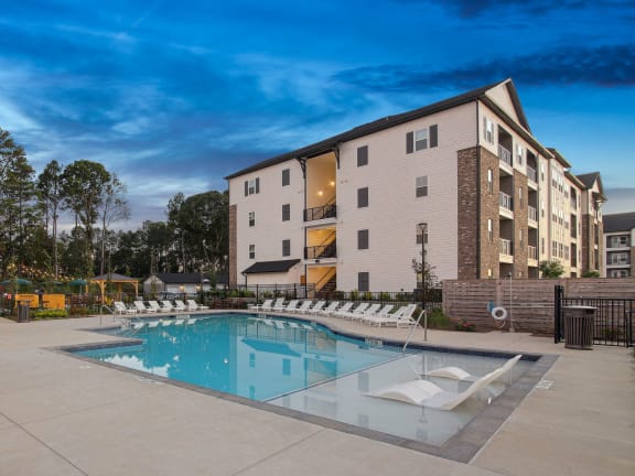 an aerial view of a resort style pool and clubhouse with tables and chairs