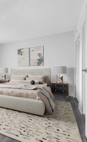 A bedroom with a large bed and a plant.
