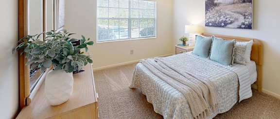 A bedroom with a bed, dresser, and mirror.