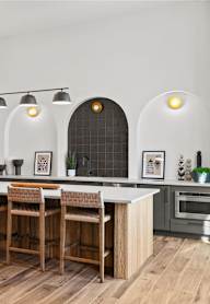 A modern kitchen with a wooden table and chairs.