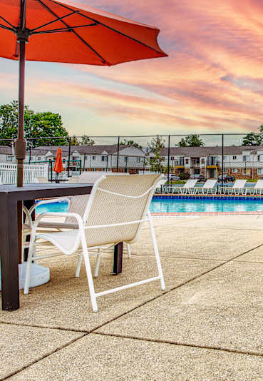 A pool area with chairs and umbrellas is shown.