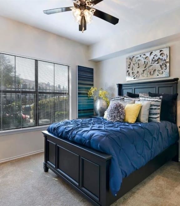 a bedroom with a bed and a ceiling fan