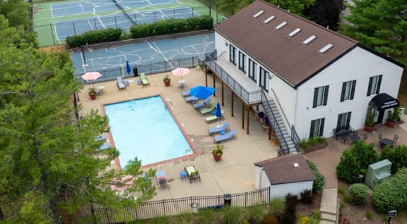 an aerial view of a house with a pool and tennis court