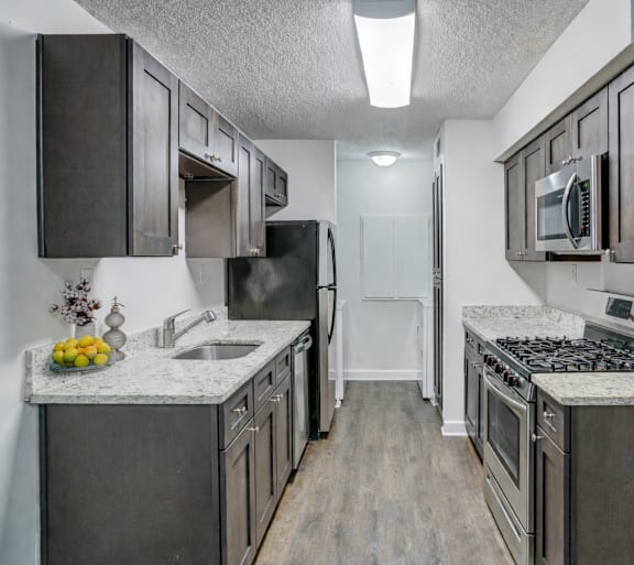 A kitchen with dark wood cabinets and stainless steel appliances.