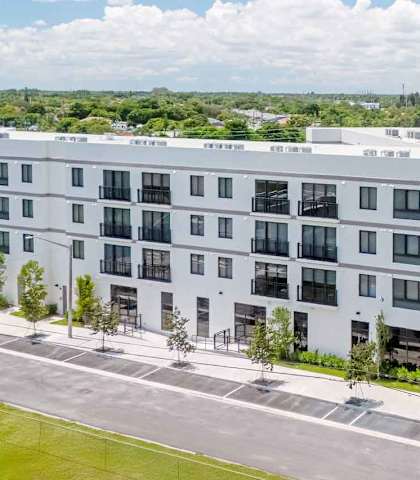 A large white building with a parking lot in front.