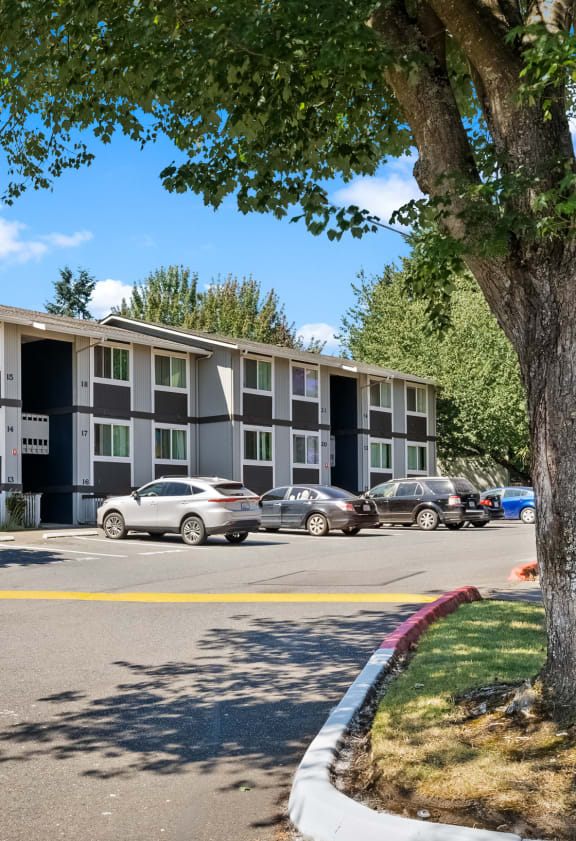 an apartment building with cars parked in front of it