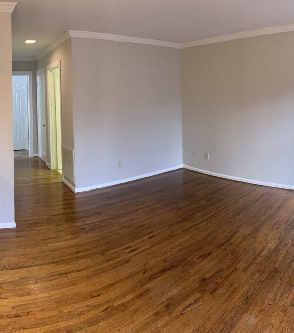 an empty kitchen and living room with wood flooring and a stove