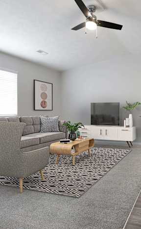 A living room with a grey couch, a grey rug, a white table, a white fan, a grey wall, a grey door, a grey chair, a grey plant, a grey sofa, a grey table, a grey couch