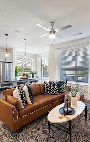 A modern living room with a brown couch and a coffee table.