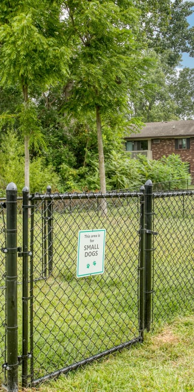 a fence in front of a building with a dog park