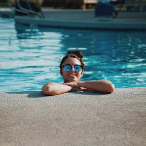 A person is relaxing by the poolside.