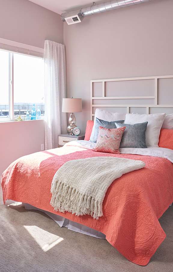 a bedroom with a bed and pillows and a window at Vue Apartments, Iowa
