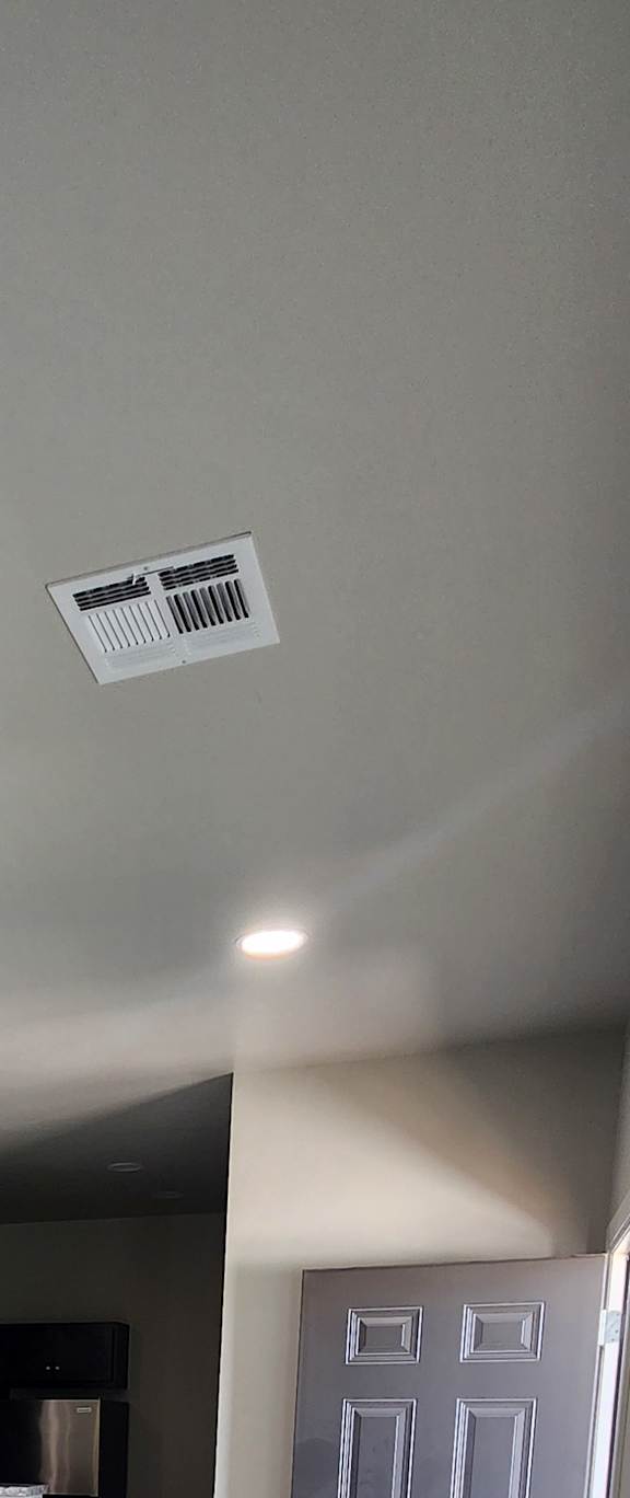 A small room with a fan and a cabinet.