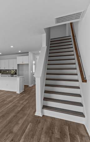 A room with a ceiling fan and a staircase.