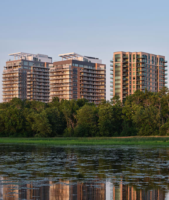Two buildings are reflected in the water.