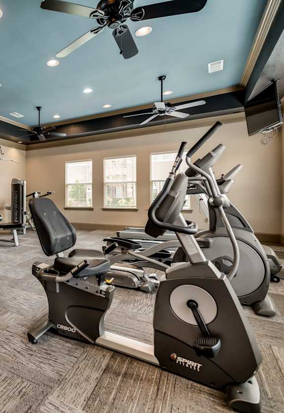 Fitness center with cardio equipment and free weights at Timber Creek Apartments in Sulphur Springs, TX