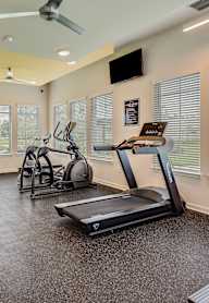 A spacious home gym with a treadmill, elliptical trainer, and other exercise equipment.