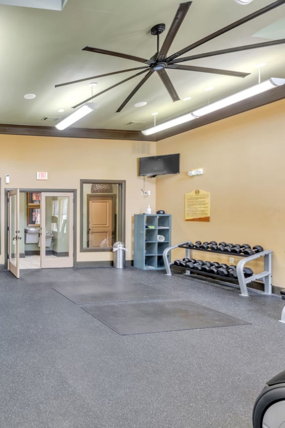 a gym with weights and cardio machines in it