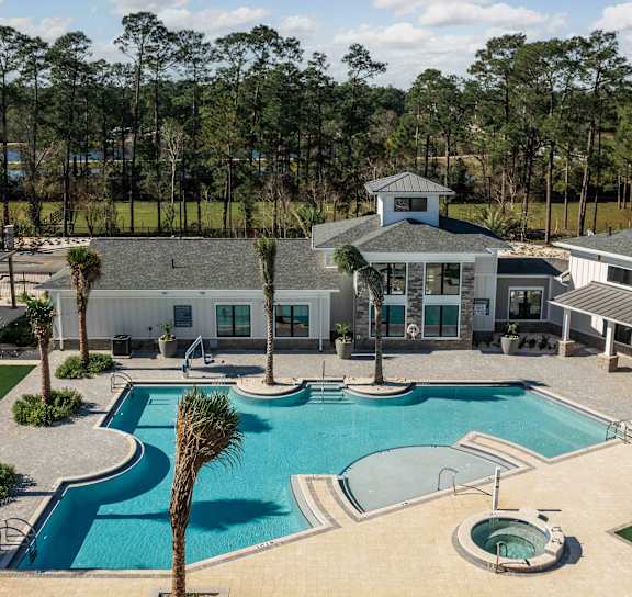 the pool is surrounded by palm trees and plants at The Quinn, Pensacola, FL, 32526