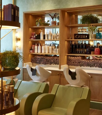 a bar filled with bottles of perfume and chairs and a table