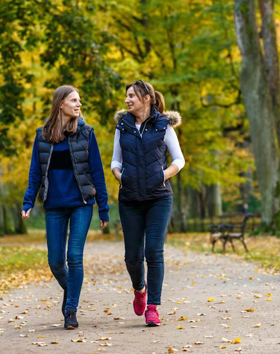 Two women walking in a park.