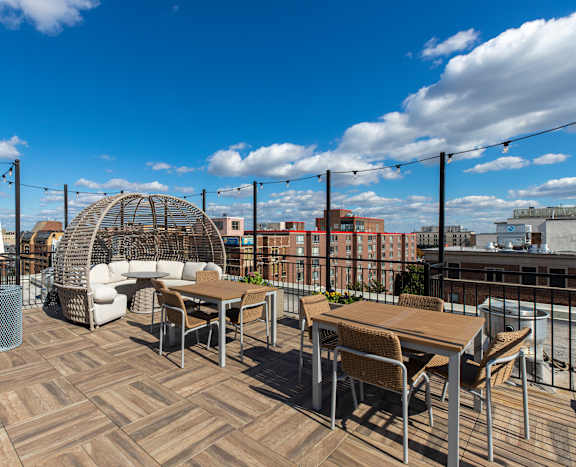 A rooftop patio with a table and chairs.