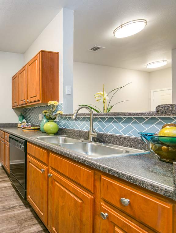 a kitchen with wood cabinets and black appliances and a sink at Sunrise Canyon, Texas