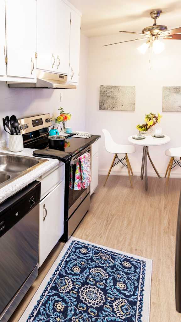 A kitchen with a refrigerator, oven, and microwave.