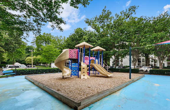 A playground with a blue slide and a yellow slide.