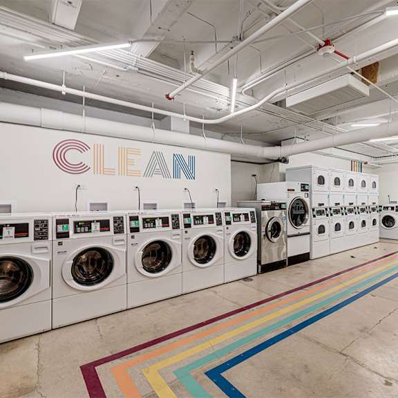 A laundromat with the word CLEAN on the wall.